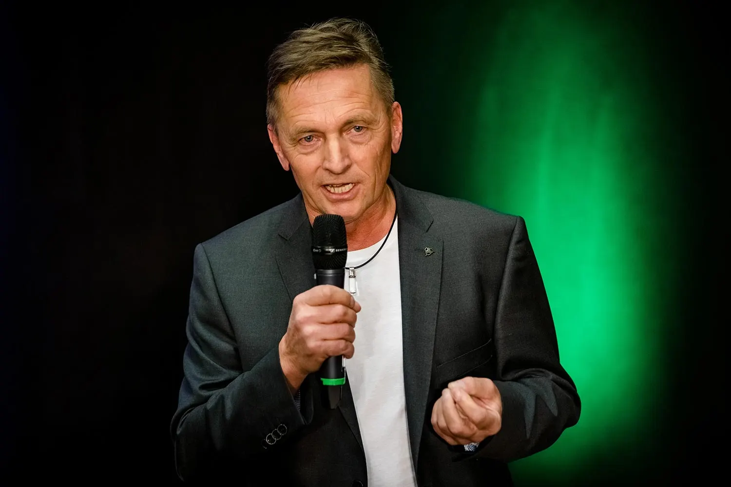 Franz Zimmermann spricht mit dem Mikrofon auf der Bühne